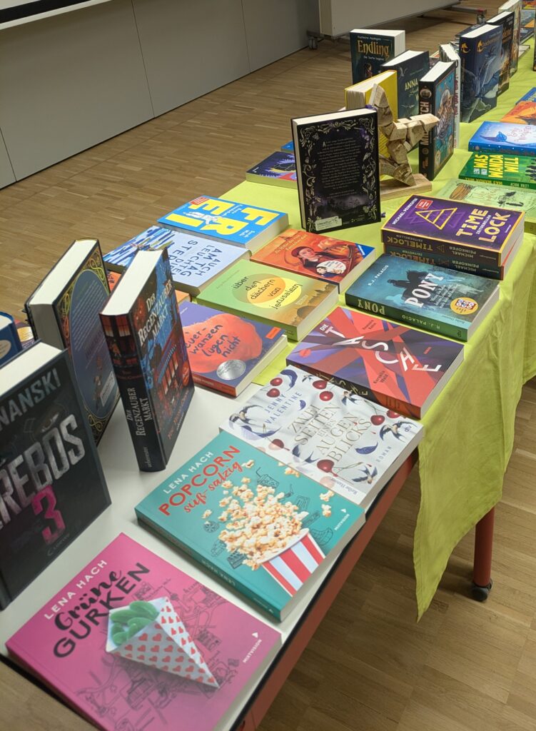 Tisch mit Büchern, die zum Anschauen ausgelegt sind, manche stehen, manche liegen